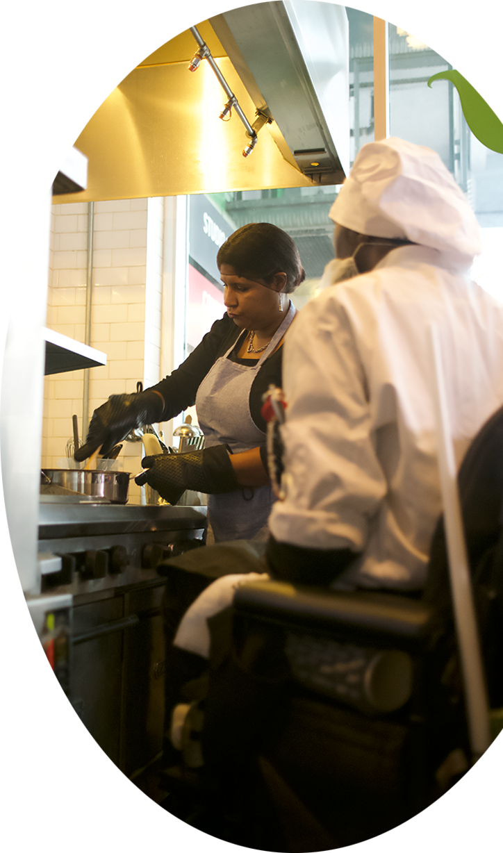 oval_image A student and Chef Smiley, who is a wheelchair user, cooking on the stove.